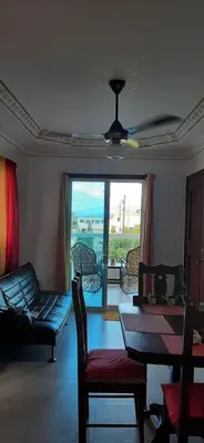 a living room with a couch and a table with a view at La casa de Marcel et Nathalie in Baní