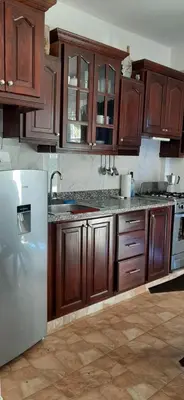 a kitchen with wooden cabinets and a stainless steel refrigerator at La casa de Marcel et Nathalie in Baní