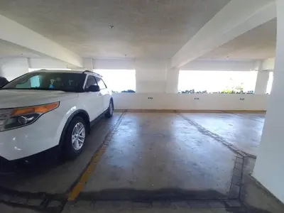 a white car parked in a parking garage at Las Olas, Juan Dolio 2bed2bath Condo in Guayacanes