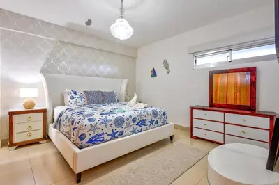 a bedroom with a bed and a dresser and a sink at Las Olas, Juan Dolio 2bed2bath Condo in Guayacanes