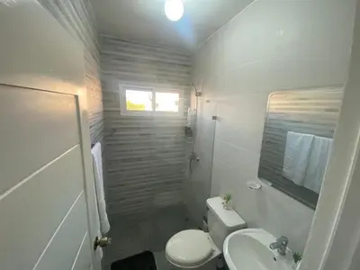 a white bathroom with a toilet and a sink at Apartamento completo en Bayahibe in Bayahibe