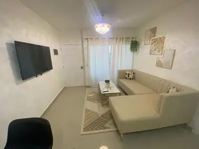 a living room with a couch and a flat screen tv at Apartamento completo en Bayahibe in Bayahibe