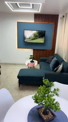 a living room with a blue couch and a tv at Departamento en el centro in Santiago de los Caballeros