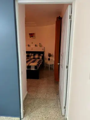 a hallway leading to a bedroom with a bed at Departamento en el centro in Santiago de los Caballeros