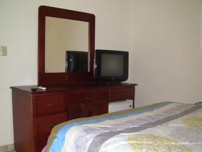 a bedroom with a dresser with a television and a mirror at Castillo Romano in Las Terrenas