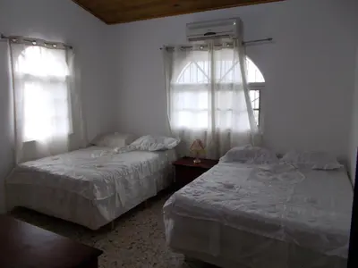 two beds in a room with two windows at Castillo Romano in Las Terrenas