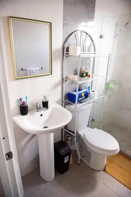 a bathroom with a sink and a toilet and a mirror at Luxury Aparment Bonao in Bonao