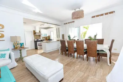 a living room with a table and chairs and a kitchen at Penthouse frente al mar Playa Las Ballenas in Las Terrenas