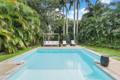 a swimming pool in a yard with palm trees at Cozy Private Family Villa at Casa de Campo - Pool, BBQ, Golf Cart in La Romana