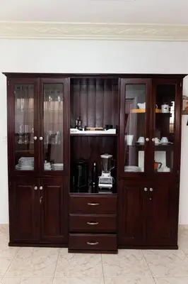 a large wooden cabinet with glass doors in a room at casa Martinez refugio sereno in Santiago de los Caballeros
