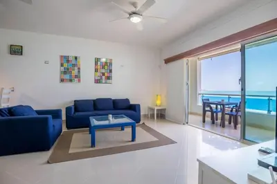 a living room with a blue couch and a table at Beachfront Cabarete Apartment in Cabarete