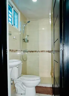 a bathroom with a toilet and a glass shower at Serene Beach Apartment in La Romana