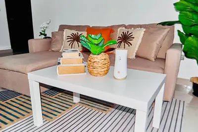 a living room with a white coffee table with books at Serene Beach Apartment in La Romana