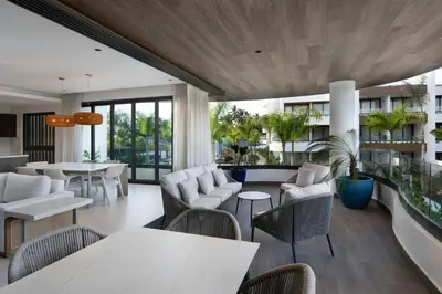 a living room with tables and chairs and windows at Donoma Las Terrenas Beach Hotel & Spa, Autograph Collection in Las Terrenas