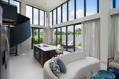 a living room with a white couch and some windows at Donoma Las Terrenas Beach Hotel & Spa, Autograph Collection in Las Terrenas