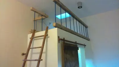 a staircase in a room with twoadders and a window at La Choza Guesthouse in Santo Domingo