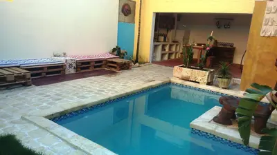 a small swimming pool in a room with a house at La Choza Guesthouse in Santo Domingo