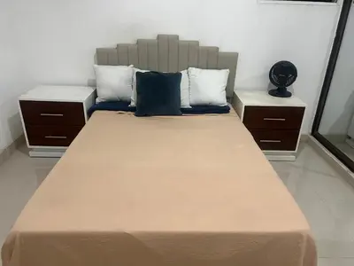 a bedroom with a large bed with two night stands at Habitación económica in Santiago de los Caballeros