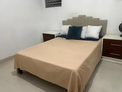 a bedroom with a large bed with blue and white pillows at Habitación económica in Santiago de los Caballeros