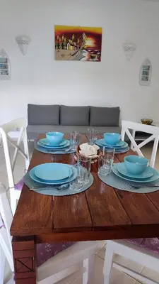 a wooden table with blue plates and glasses on it at Caribe Home Dominicus Oleandra 3 in La Laguna