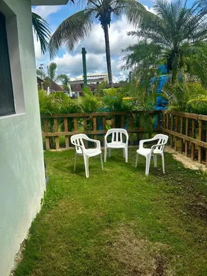 a group of white chairs sitting in the grass at Apts dentro de Residencial Soficu Eden in La Laguna