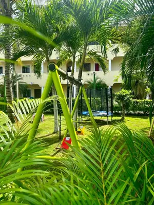 a green bike parked in a yard with palm trees at Apts dentro de Residencial Soficu Eden in La Laguna