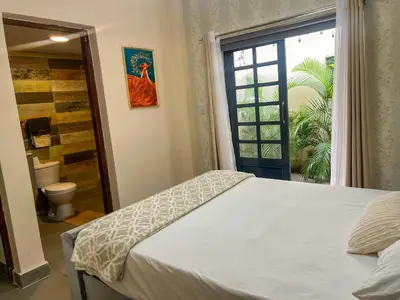 a bedroom with a bed and a bathroom with a window at Colonial leyton apartment in Santo Domingo