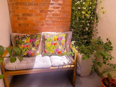 a bench with pillows on it next to a brick wall at Colonial leyton apartment in Santo Domingo