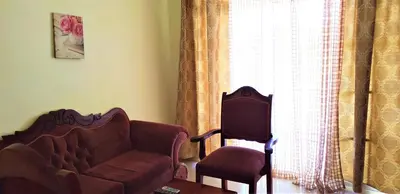 a living room with a couch and a chair and a window at Costambar Beachfront Pool Apartment in San Felipe de Puerto Plata