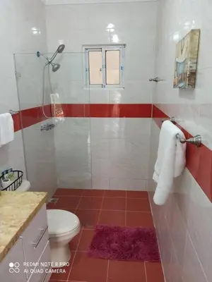 a bathroom with a toilet and red and white tiles at Modern Country Side Lux Apt in La Ceibita