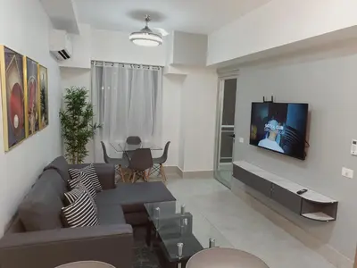 a living room with a couch and a tv on a wall at Boca del Mar III, apartamento 411 in Boca Chica