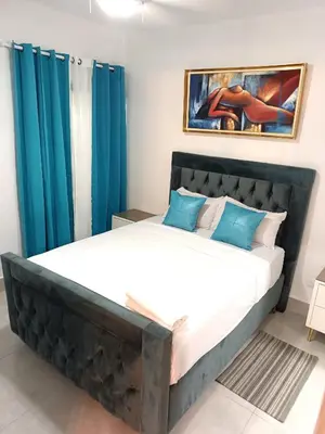 a bedroom with a large bed with blue curtains at Boca del Mar III, apartamento 411 in Boca Chica