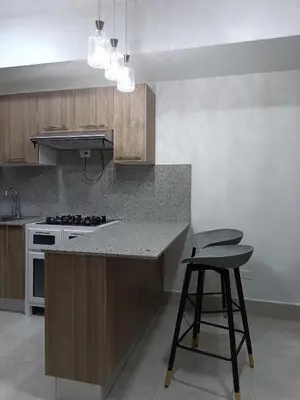 a kitchen with a counter and a stove and a stool at Boca del Mar III, apartamento 707 in Cuevas