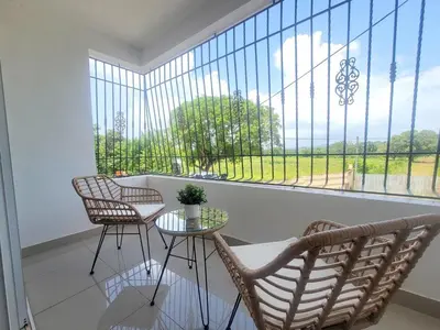 a balcony with chairs and a table and a large window at The Loft Bayaguana in Bayaguana