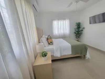 a bedroom with a bed and a table with a lamp at The Loft Bayaguana in Bayaguana