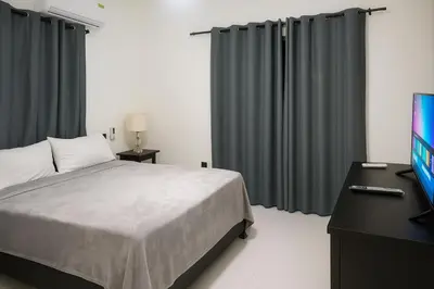 a bedroom with a bed and a flat screen tv at Modern 2BR Apartment 3 Min from Airport with Free Parking in Sosúa