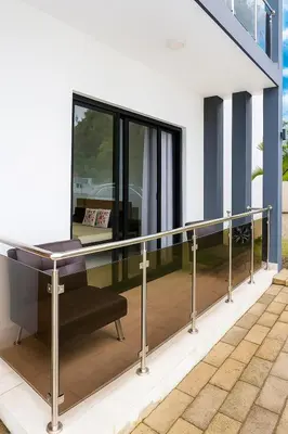 a glass railing on a balcony with a desk at Modern 2BR Apartment 3 Min from Airport with Free Parking in Sosúa