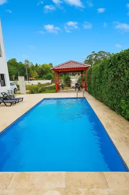 a large blue swimming pool with a gazebo at Modern 2BR Apartment 3 Min from Airport with Free Parking in Sosúa