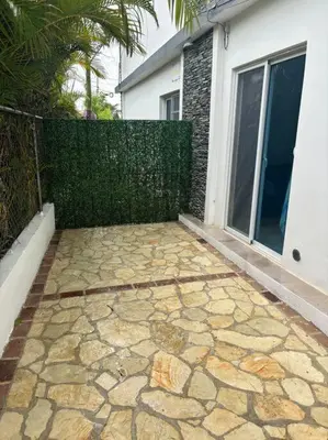 a backyard with a fence and a stone patio at Apartment, Close to the Bayahibe Beach in Bayahibe