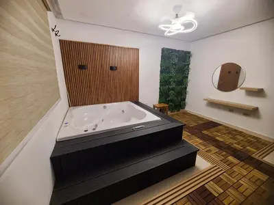 a bath tub in a bathroom with a wooden door at Centrico con yacuzzi privado in Santiago de los Caballeros