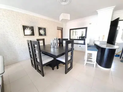a dining room with a black table and chairs at Centrico con yacuzzi privado in Santiago de los Caballeros
