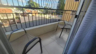 a balcony with two chairs and a view of a street at Centrico con yacuzzi privado in Santiago de los Caballeros