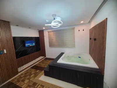 a bathroom with a jacuzzi tub and a television at Centrico con yacuzzi privado in Santiago de los Caballeros