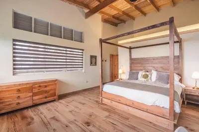 a bedroom with a canopy bed and a wooden dresser at Majestic villa with stunning views in Jarabacoa in Buena Vista