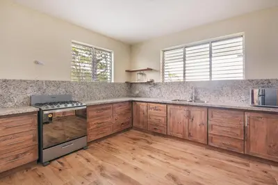 a large kitchen with wooden cabinets and stainless steel appliances at Majestic villa with stunning views in Jarabacoa in Buena Vista