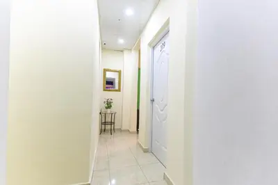 a hallway with a white door and a table at Casa de Huespedes Colonial in Santo Domingo