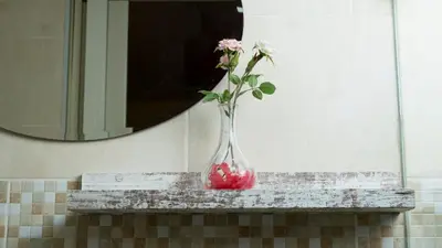 a vase with a flower in it sitting on a shelf at Casa de Huespedes Colonial in Santo Domingo