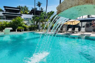a fountain in the middle of a swimming pool at Aligio Beachfront Resort & Spa in Las Terrenas
