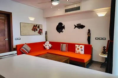 a living room with a red couch and a table at Aligio Beachfront Resort & Spa in Las Terrenas
