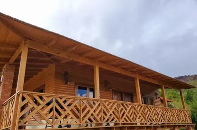 a log cabin with a large wooden deck at Villas Las Neblinas in Constanza